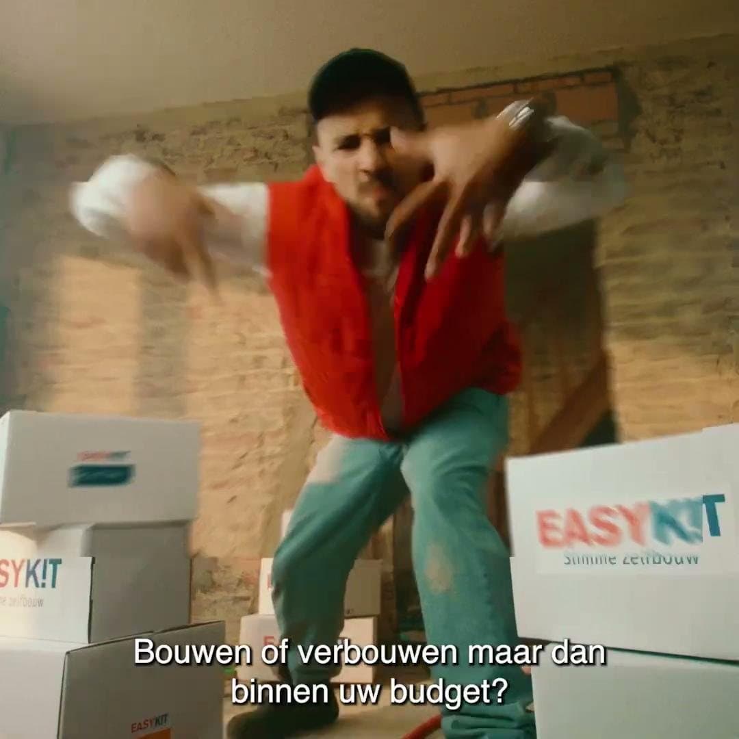 Still from the Easykit video: a man in a red bodywarmer dancing between Easykit boxes