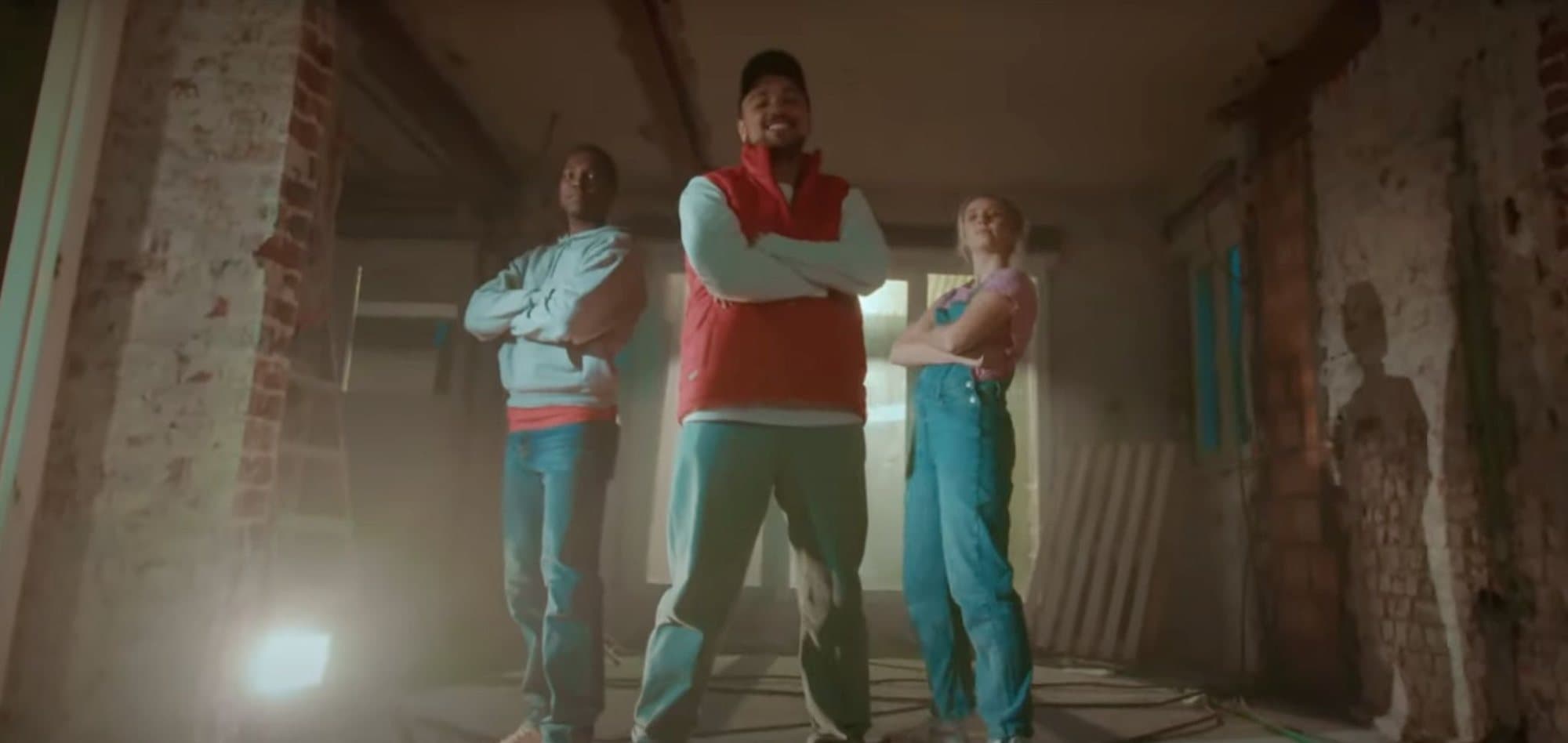 Three performers in work clothes in a half-renovated room, from the Easykit rap video clip